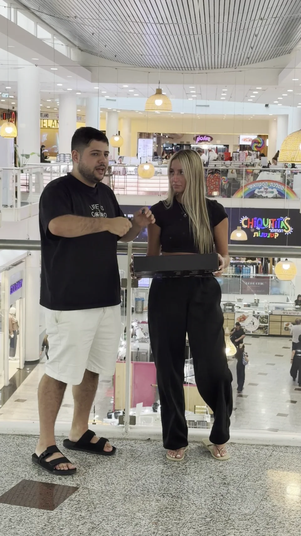 אופק אלון מציג מוצר למרואיינת במהלך ראיון רחוב